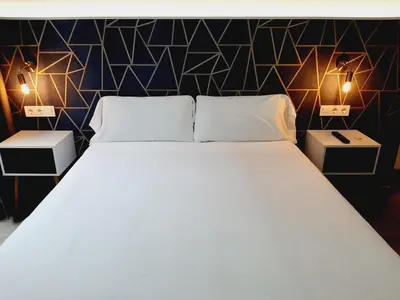 a bedroom with a large bed with two night stands at Hostal Laia by gaiarooms in Barcelona