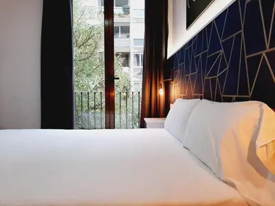 a bedroom with a white bed and a window at Hostal Laia by gaiarooms in Barcelona