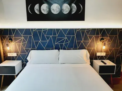 a bedroom with a white bed and two night stands at Hostal Laia by gaiarooms in Barcelona