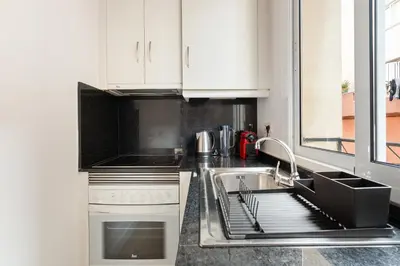 a kitchen with white cabinets and a sink at Lodging Apartments Barceloneta Beach Studio 12 in Barcelona