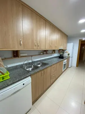 a kitchen with wooden cabinets and a sink at Sitges Living Apartment in Sitges
