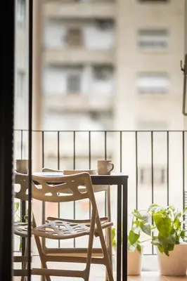 a table and chairs on a balcony with plants at Stay U-nique Apartments Villarroel in Barcelona