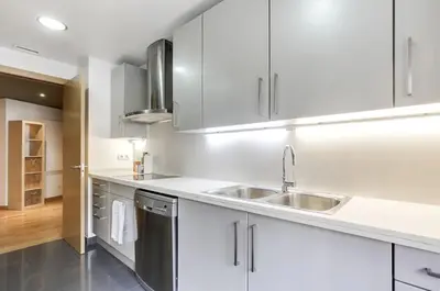 a kitchen with white cabinets and a sink at Stay U-nique Apartments Diagonal Mar in Barcelona