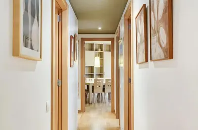 a hallway leading to a dining room with paintings on the walls at Stay U-nique Apartments Diagonal Mar in Barcelona