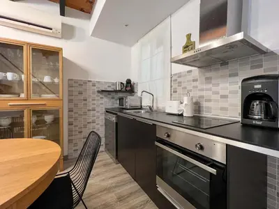 a kitchen with a table and a counter top at Stay U-nique Apartments Tordera in Barcelona