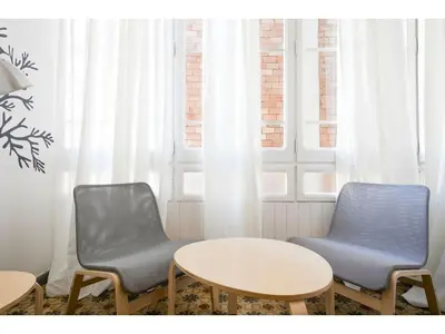 two chairs and a table in a room with windows at Stay U-nique Apartments Napols I in Barcelona