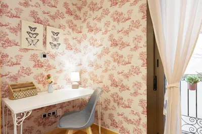 a desk and a chair in a room with pink wallpaper at Stay U-nique Apartments Terrassa in Barcelona