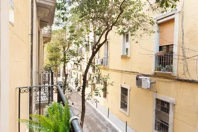 an empty street with a tree in the middle of a building at Stay U-nique Apartments Terrassa in Barcelona