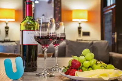 a table with two glasses of wine and a plate of fruit at Stay U-nique Apartments Carretes in Barcelona