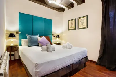 a bedroom with a large bed with a blue headboard at Stay U-nique Apartments Carretes in Barcelona