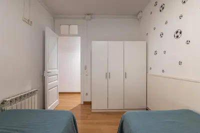 a bedroom with two beds and white cabinets at Stay U-nique Apartments Sant Antoni in Barcelona