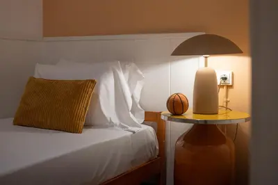a bed with a lamp and a basketball on a table at Stay U-nique Apartments Sant Antoni in Barcelona