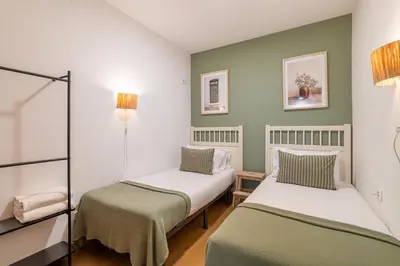 two beds in a room with green and white walls at Stay U-nique Apartments Passatge de Font in Barcelona