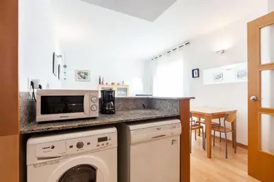 a kitchen with a washing machine and a microwave at Stay U-nique Apartments Industria in Barcelona