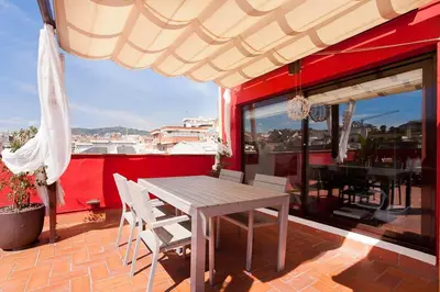 a table and chairs on a balcony with a red wall at Stay U-nique Apartments Sagues in Barcelona