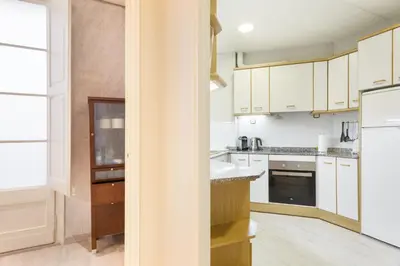 a kitchen with white cabinets and a refrigerator at Stay U-nique Apartments Manso in Barcelona