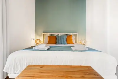 a bedroom with a large bed with orange pillows at Lodging Apartments Barceloneta Beach Studio P2 in Barcelona