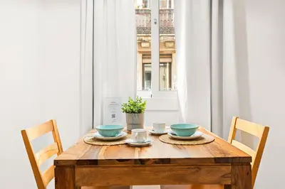 a wooden table with two bowls on it in front of a window at Lodging Apartments Barceloneta Beach Studio P2 in Barcelona