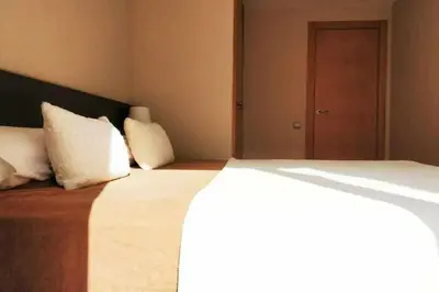 a bedroom with a large bed with white pillows at Mazi Apartments Terrace in Mataró