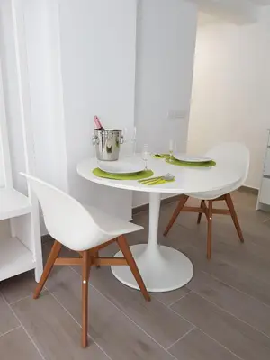 a white table and chairs in a room at Eros Apartament in Calella