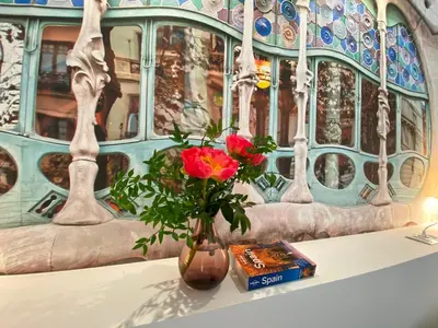 a vase with a flower and a book on a table at The Yellow House by MyRentalHost in Barcelona