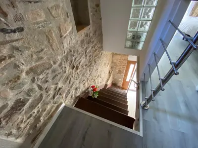 a staircase in a house with a stone wall at The Yellow House by MyRentalHost in Barcelona