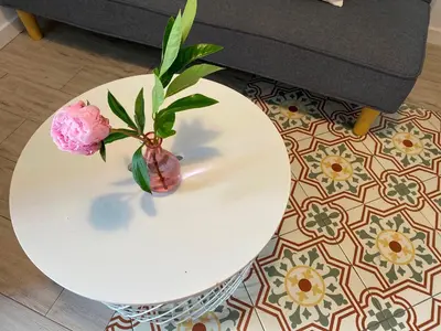 a white table with a vase with flowers on it at The Yellow House by MyRentalHost in Barcelona