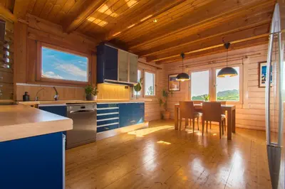 a kitchen with blue cabinets and a table with chairs at Finland House Barcelona- Ideal familias in Argentona