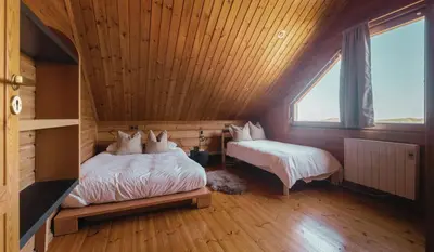 two beds in a room with a wooden ceiling at Finland House Barcelona- Ideal familias in Argentona
