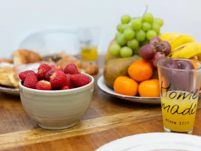 a wooden table with a bowl of fruit and a plate of fruit at Matarolux20 in Mataró