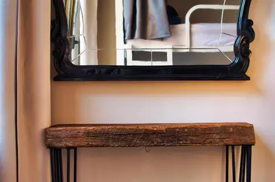 a mirror on a wall with a wooden bench at Factory Hostels Barcelona in Barcelona