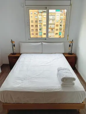 a bed with two towels on it in a room with a window at Incredible 2BR Penthouse with Urban Rooftop Garden in Barcelona