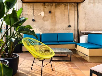 a yellow chair and a couch on a patio at Incredible 2BR Penthouse with Urban Rooftop Garden in Barcelona