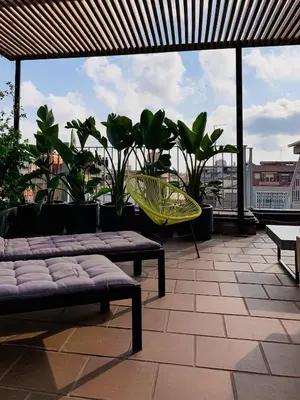 a patio with a couch and a chair and plants at Incredible 2BR Penthouse with Urban Rooftop Garden in Barcelona