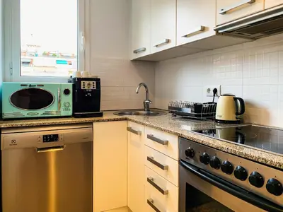 a kitchen with a microwave oven and a sink at Incredible 2BR Penthouse with Urban Rooftop Garden in Barcelona