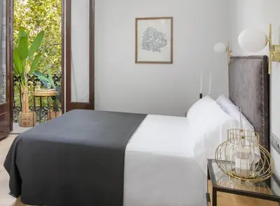 a bedroom with a black and white bed and a window at La Maison de Barcelone in Barcelona