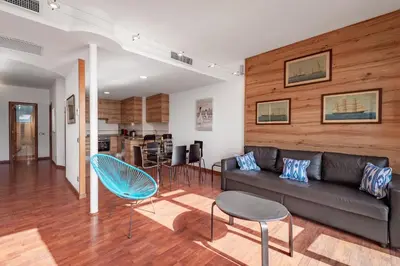 a living room with a couch and a table and chairs at InSitges Ribera's Beach in Sitges
