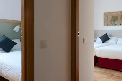 a room with two beds and a door with a mirror at MH Apartments Gracia in Barcelona