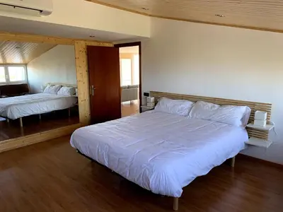 a bedroom with a large white bed and a mirror at Apartamento entero con vistas panorámicas in Avinyonet