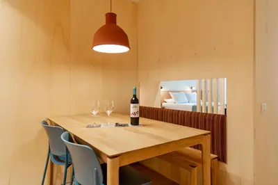 a wooden table with two glasses and a bottle of wine at Jardinets De Gràcia by The 5ve Soul in Barcelona