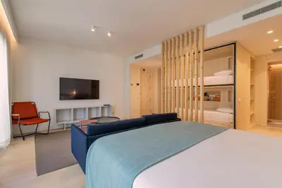 a bedroom with a bed and a tv on a wall at Jardinets De Gràcia by The 5ve Soul in Barcelona
