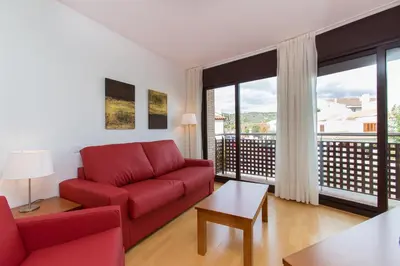 a living room with a red couch and a large window at Sweet Apartments in Sant Pere de Ribes
