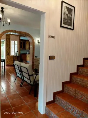 a living room with stairs and a table and chairs at Casa Flores del Mediterráneo in Badalona