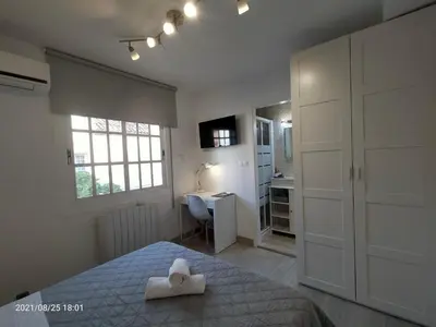 a bedroom with a bed and a sink and a desk at Casa Flores del Mediterráneo in Badalona