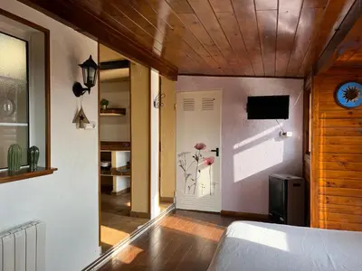 a bedroom with a bed and a door with a television at La Bruixa Rural in Dosríus