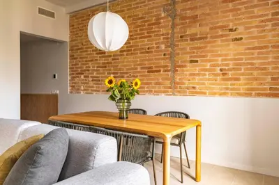 a dining room table with a vase of flowers on it at Aspasios Garden Apartments in Barcelona