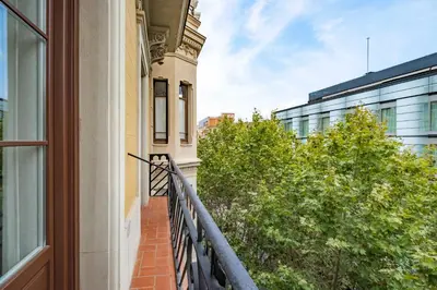 a balcony of a building with a window and trees at Aspasios Garden Apartments in Barcelona