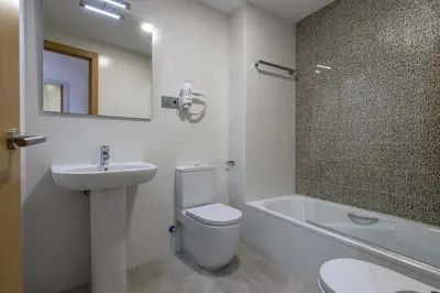 a bathroom with a toilet and a sink and a mirror at Apartamento centro histórico en Manresa in Manresa