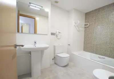 a white bathroom with a sink and a toilet at Apartamento centro histórico en Manresa in Manresa