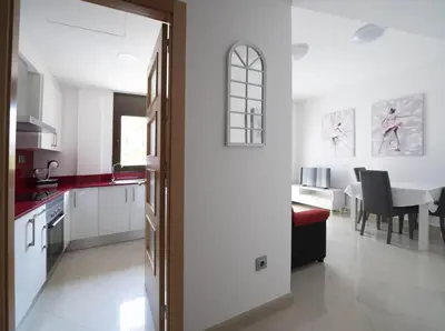 a kitchen with white cabinets and a dining room at Apartamento centro histórico en Manresa in Manresa